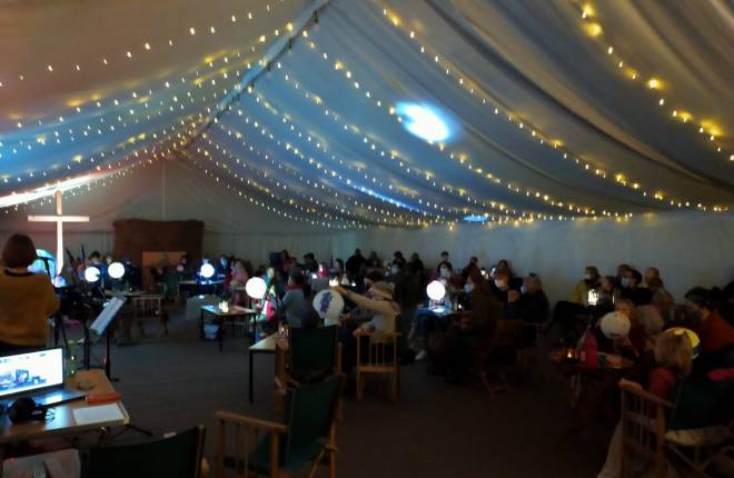 Tent with lights and people with globes