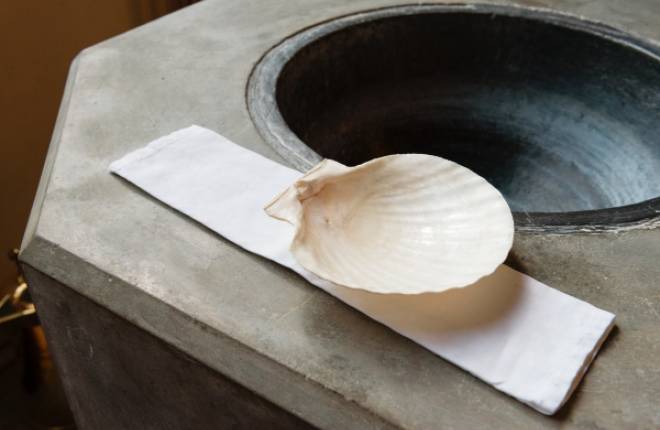 Scallop shell on the side of a baptism font.