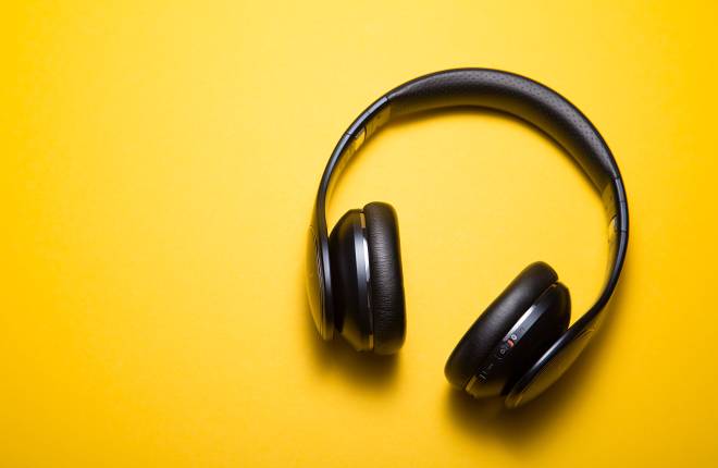 Black headphones placed on a yellow table.