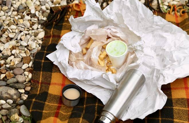 Fish and chips and a flask of tea on a picnic rug