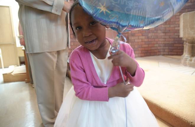 A little girl holding a helium balloon