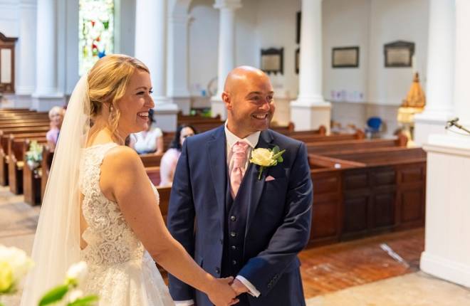 A bride and groom smiling at the front of church