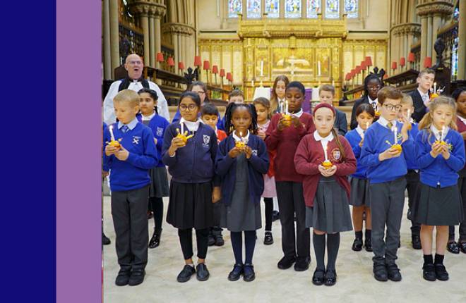 Children stand with their Chris-tingles in a church service.
