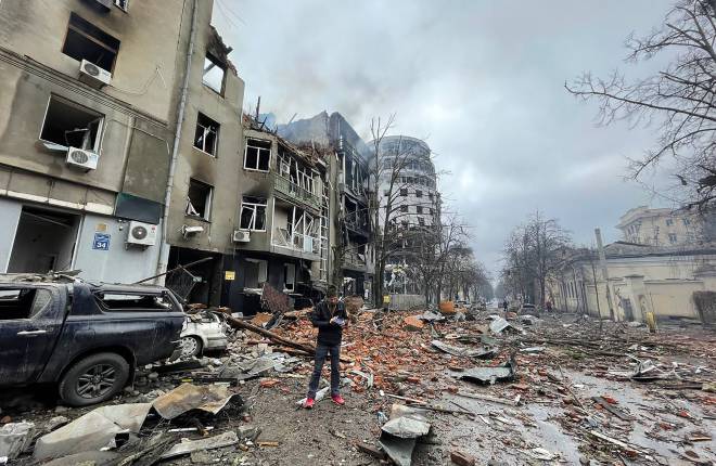 Man standing on the street in Kharkiv, Ukraine, amid bomb damage 
