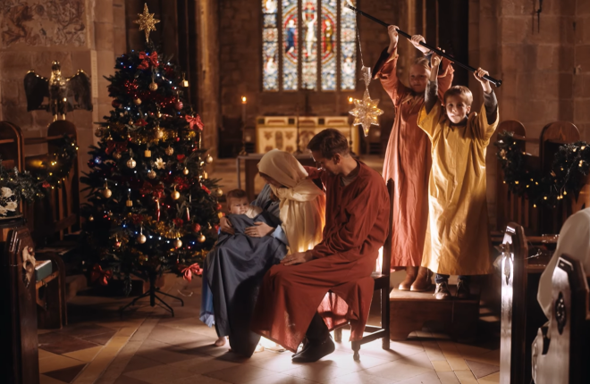 A still from the film showing a family in a nativity scene in a church